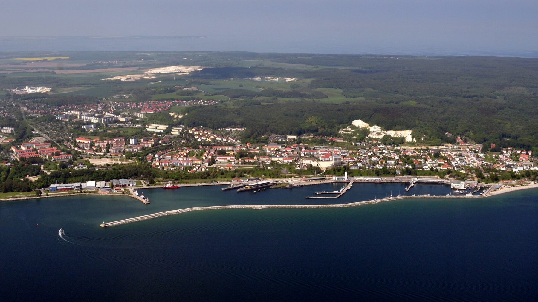Luftbild von Sassnitz mit Hafen, Mole, Stadt und den bewaldeten Höhen des Nationalparks Jasmund